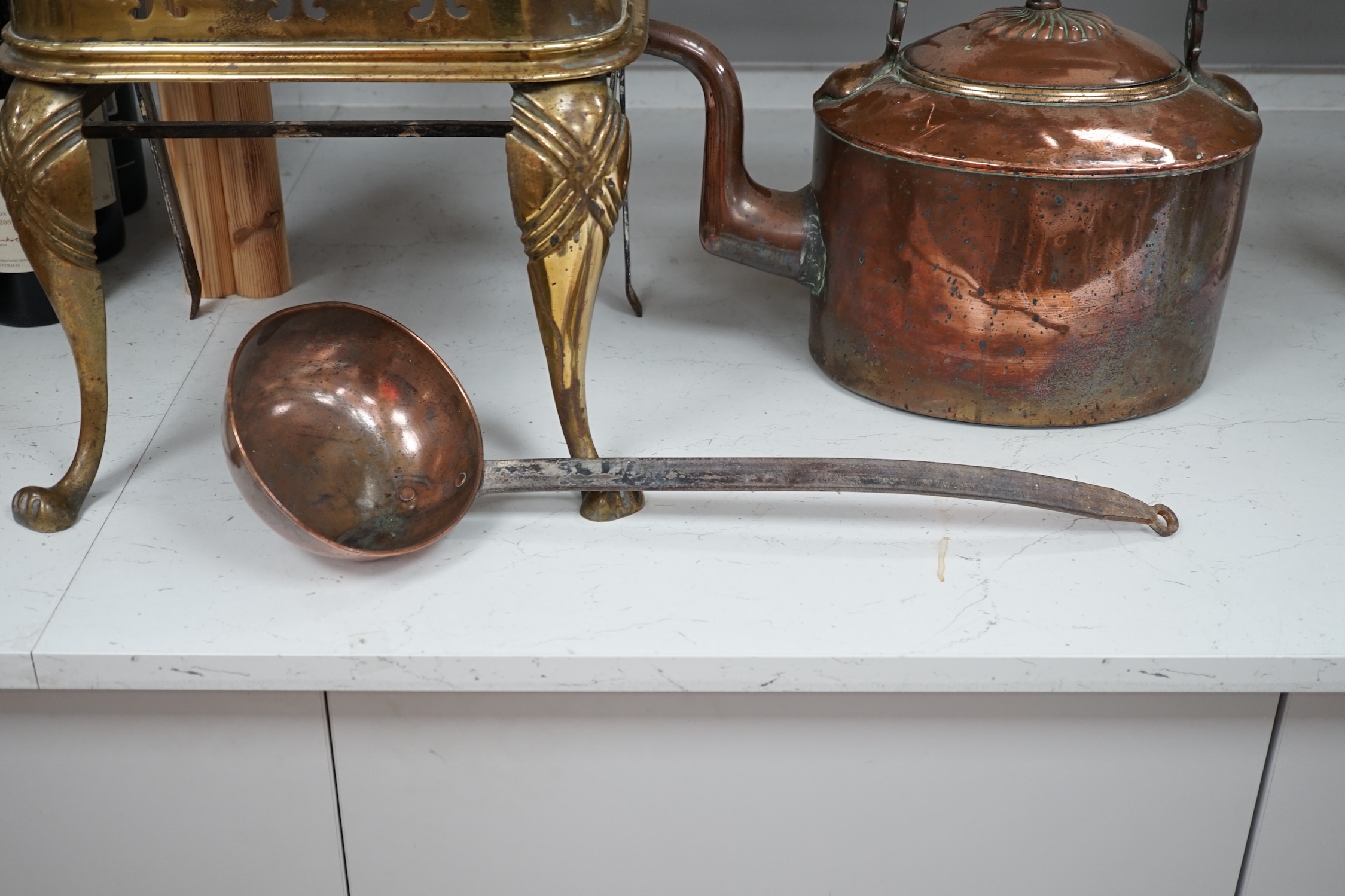 A late Victorian copper kettle, a brass stand and a ladle, largest 39cm wide. Condition - fair